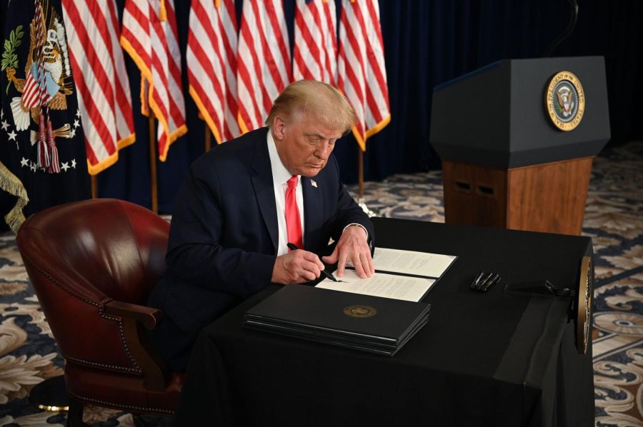 President Donald Trump signs executive orders extending coronavirus economic relief, during a news conference in Bedminster, New Jersey, on August 8, 2020.