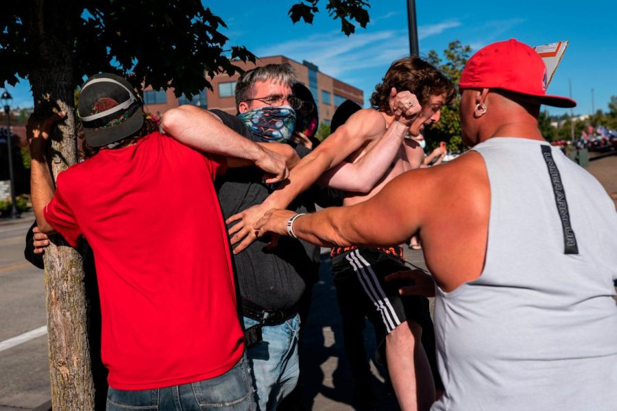 A black Lives Matter protester scuffles with attendees of a pro-Trump rally during an event held to show support for the president on August 29, 2020 in Clackamas, Oregon.