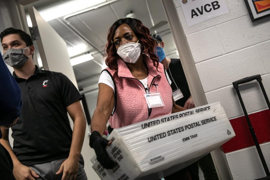 LANSING, MICHIGAN - NOVEMBER 03: An election worker carries absentee ballots for counting at the Lansing city clerk's office on election night on November 03, 2020 in Lansing, Michigan. President Trump narrowly won Michigan in 2016, and both he and Joe Biden campaigned heavily in the battleground state in 2020. (Photo by John Moore/Getty Images)