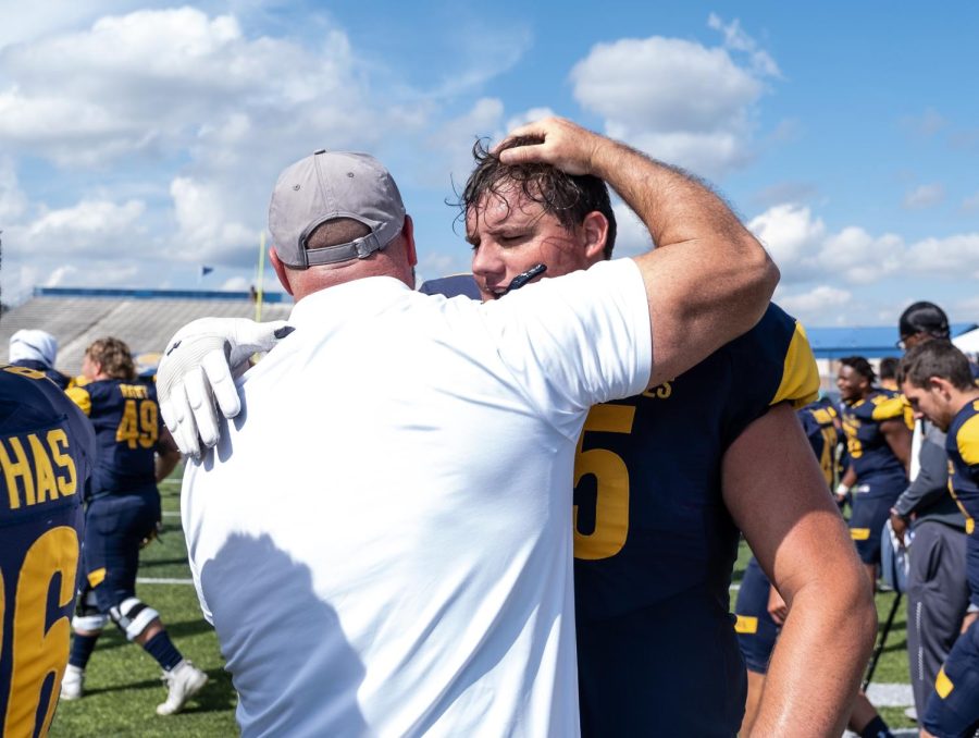 Junior offensive lineman Adam Gregoire hugs his coach after Kent State beat Kennesaw State University 26-23 in overtime. Saturday, September 7, 2019.