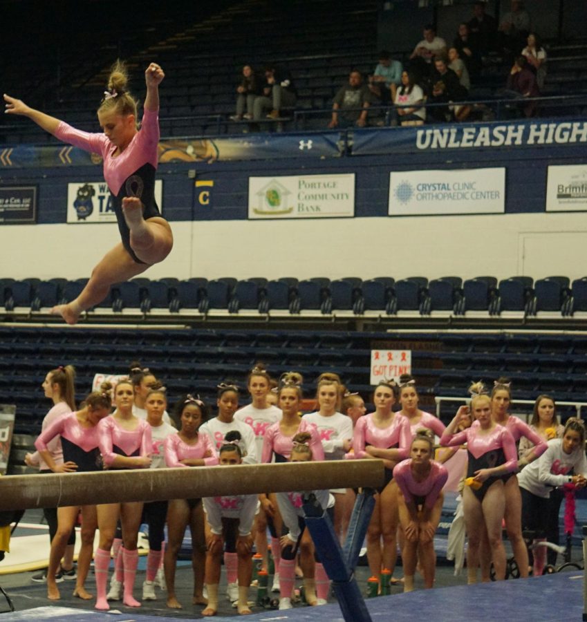 Sophomore Riley Danielson does a split in mid-air on the balance beam at the annual pink meet against Bowling Green, the College at Rockport and Ursinus College at the M.A.C. Center on Friday, Feb. 28, 2020.