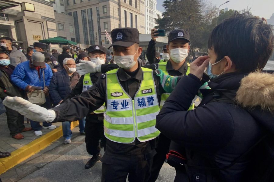 Police attempt to stop journalists from recording footage outside the Shanghai Pudong New District People's Court, where Chinese citizen journalist Zhang Zhan - who reported on Wuhan's Covid-19 outbreak and placed under detention since May - is set for trial in Shanghai on December 28, 2020.