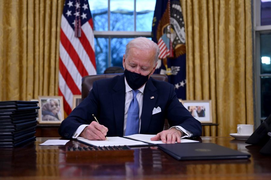 US President Joe Biden sits in the Oval Office as he signs a series of orders at the White House in Washington, DC, after being sworn in at the US Capitol on January 20, 2021.