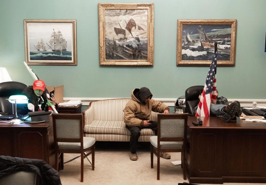 Supporters of US President Donald Trump sit inside the office of US Speaker of the House Nancy Pelosi as he protest inside the US Capitol in Washington, DC, January 6, 2021. - Demonstrators breeched security and entered the Capitol as Congress debated the a 2020 presidential election Electoral Vote Certification. (Photo by SAUL LOEB / AFP) (Photo by SAUL LOEB/AFP via Getty Images)