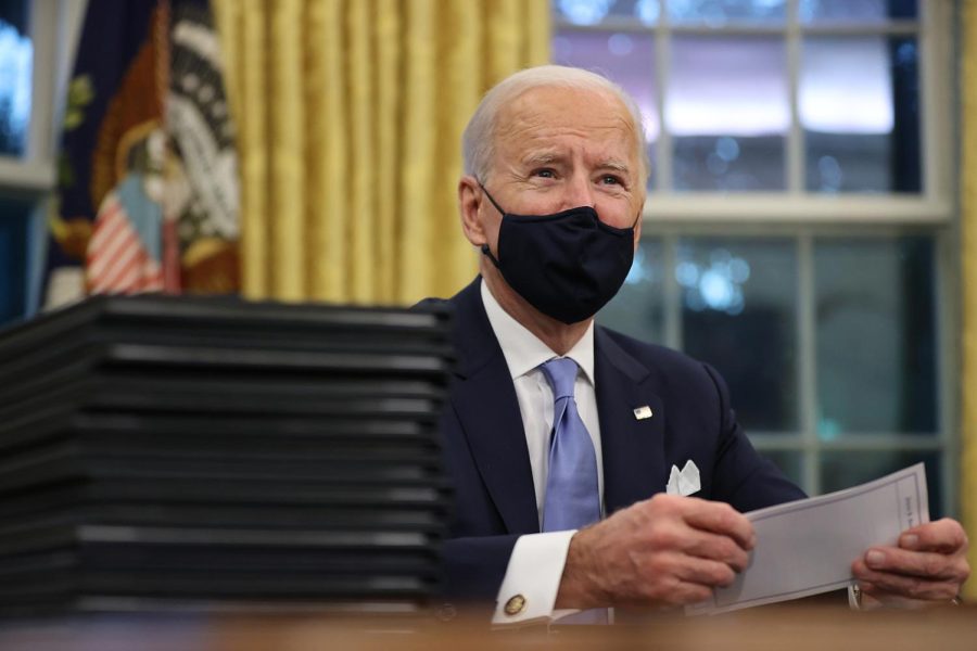 WASHINGTON, DC - JANUARY 20: U.S. President Joe Biden prepares to sign a series of executive orders at the Resolute Desk in the Oval Office just hours after his inauguration on January 20, 2021 in Washington, DC. Biden became the 46th president of the United States earlier today during the ceremony at the U.S. Capitol. (Photo by Chip Somodevilla/Getty Images)