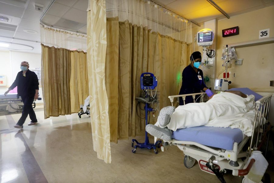 APPLE VALLEY, CALIFORNIA - JANUARY 27: (EDITORIAL USE ONLY) A clinician cares for a patient in a COVID-19 isolation area at Providence St. Mary Medical Center on January 27, 2021 in Apple Valley, California. The hospital was treating over 170 COVID-19 patients at the peak of the surge but has seen a recent decrease and is currently caring for 87 confirmed or suspected coronavirus patients. California has eased lockdown orders amid fears of a new coronavirus variant. (Photo by Mario Tama/Getty Images)