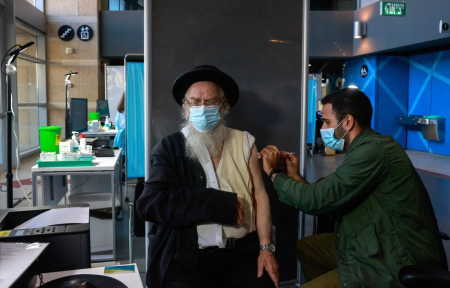 A healthcare worker administers a COVID-19 vaccine to an ultra-Orthodox Jewish man at Israel's Clalit Health Services in Jerusalem, on January 6, 2021. (Photo by MENAHEM KAHANA / AFP) (Photo by MENAHEM KAHANA/AFP via Getty Images)