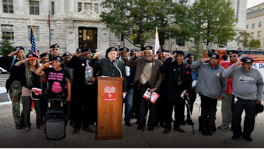 Hector Rodriguez (middle) salutes aside members of Veterans United for D.C. Statehood in May 2017.