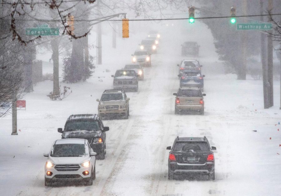 Cars head east on Kessler Avenue as the snow falls on Monday, Feb. 15, 2021, in Indianapolis. A winter storm is expected to bring snowfall for multiple days could dump between 6 to 10 inches of snow across Central Indiana. Snowy Weather