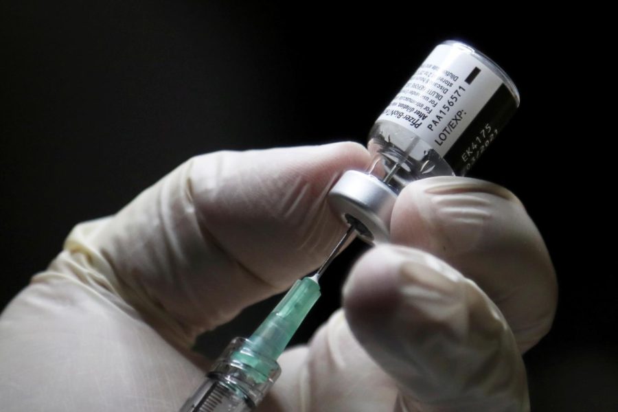 A healthcare worker prepares to administer a Pfizer/BioNTEch coronavirus disease (Covid-19) vaccine at The Michener Institute, in Toronto, Ontario on December 14, 2020. - Ontario, Canada's most populous province and one of the hardest hit by the pandemic, had 1,940 new cases and 23 deaths on Monday. The province is expected to give its next doses to nursing home workers as a priority, according to media reports. (Photo by CARLOS OSORIO / POOL / AFP) (Photo by CARLOS OSORIO/POOL/AFP via Getty Images)