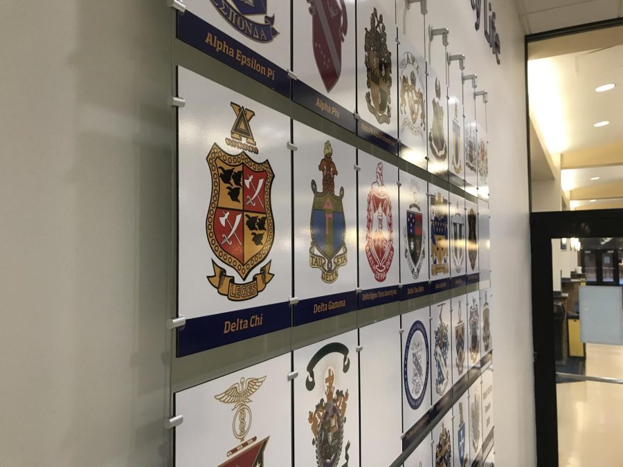 The crests of several Greek life organizations on a wall near the dining hall known as the Hub in the Kent Student Center. Collin's anti-hazing law in Ohio will criminalize hazing by any organizations, including campus Greek life.