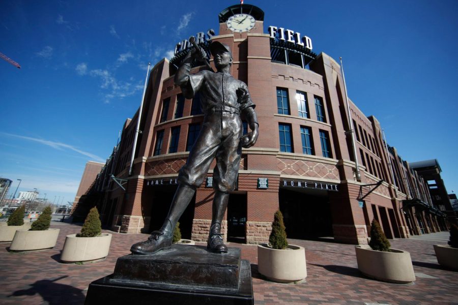 A scuplture entitled "The Player" by George Lundeen stands outside the main entracne to Coors Field, home of Major League Baseball's Colorado Rockies, as the sidewalks stand empty on the league's scheduled opening day for the 2020 season with a statewide stay-at-home order taking effect to reduce the spread of the new coronavirus Thursday, March 26, 2020, in Denver. The new coronavirus causes mild or moderate symptoms for most people, but for some, especially older adults and people with existing health problems, it can cause more severe illness or death. (AP Photo/David Zalubowski)