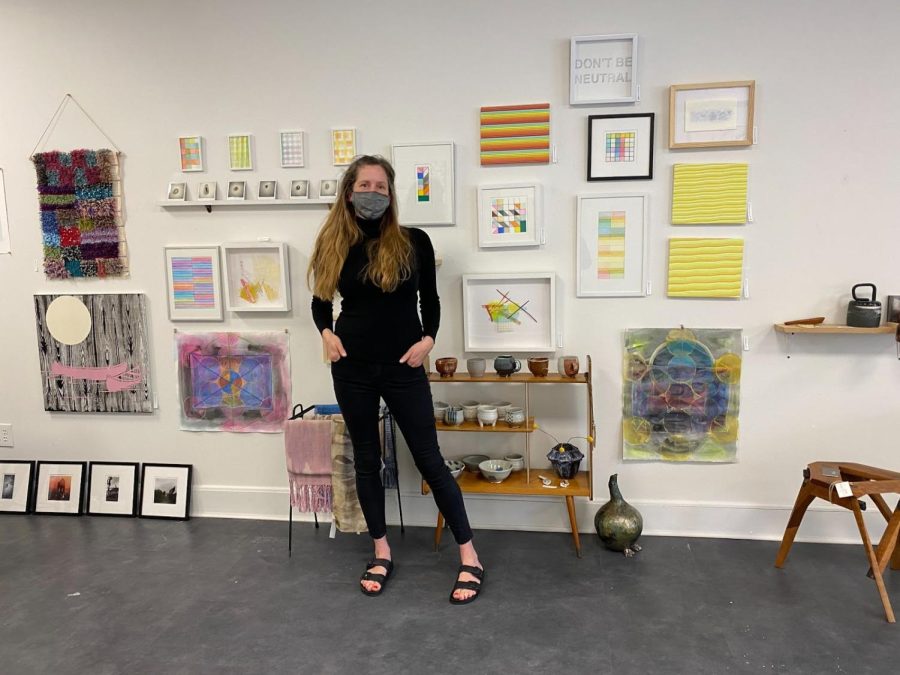 Kelly Dietrick in front of local artists' artwork.