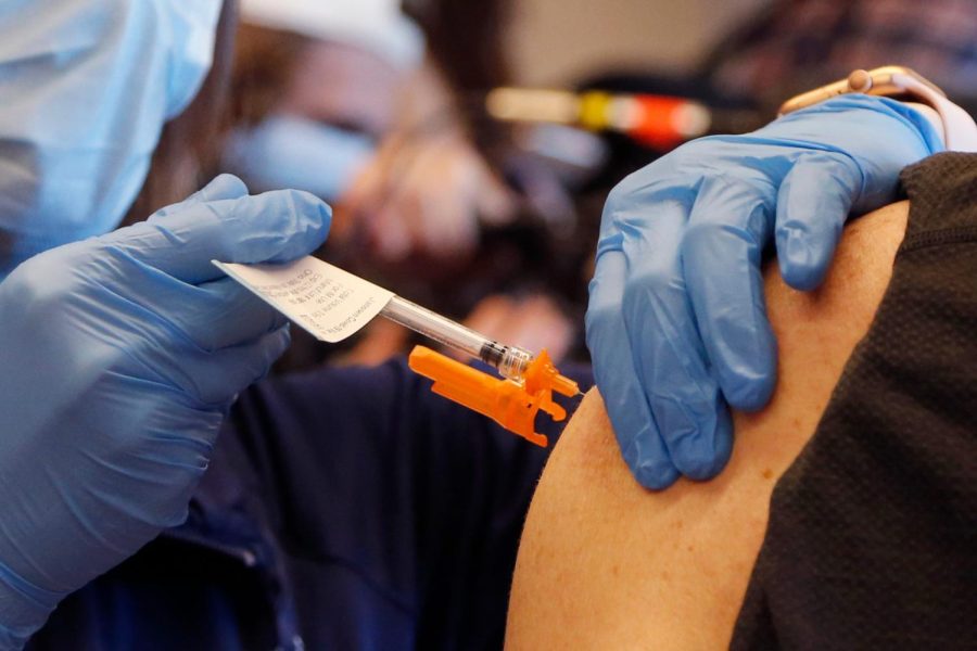 Ohio State University clinic manager Paige Blankenship, left, administers one of the first Johnson &amp; Johnson COVID-19 vaccines to Osvaldo Campanella Tuesday, March 2, 2021, in Columbus, Ohio. (AP Photo/Jay LaPrete)