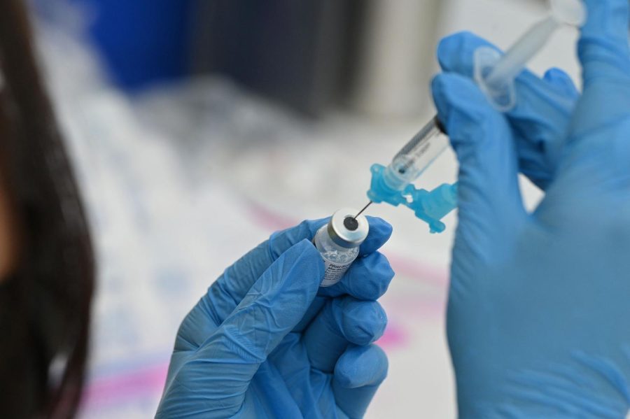 A healthcare worker fills a syringe with Pfizer Covid-19 vaccine at a community vaccination event in a predominately Latino neighborhood in Los Angeles, California, August 11, 2021. - All teachers in California will have to be vaccinated against Covid-19 or submit to weekly virus tests, Governor Gavin Newsom announced on August 11, as authorities grapple with exploding infection rates. The number of people testing positive for the disease has surged in recent weeks, with the highly infectious Delta variant blamed for the bulk of new cases. (Photo by Robyn Beck / AFP) (Photo by ROBYN BECK/AFP via Getty Images)