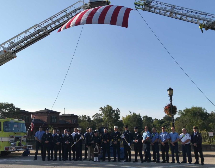 Members of the Kent police and fire departments gather on the West Main Street Bridge to commemorate the twentieth anniversary of the 9/11 attacks.