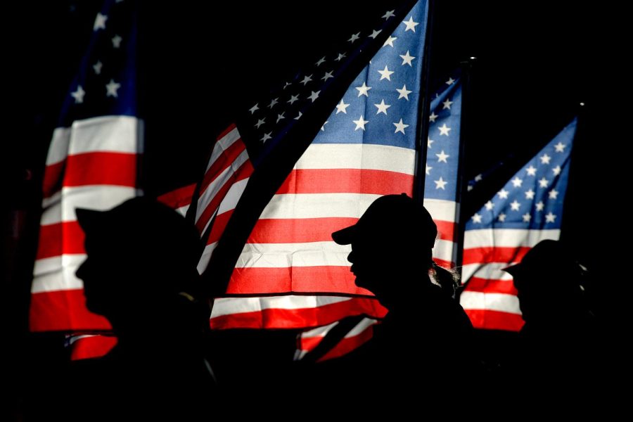 Patriot Guard rider and U.S. Navy veteran Ron Connally, center, of Oak Harbor, holds a flag at the 9/11 ceremony at Evergreen-Rotary Park in Bremerton, Wash. on Tuesday, Sept. 11, 2012. (AP Photo/Kitsap Sun, Larry Steagall)