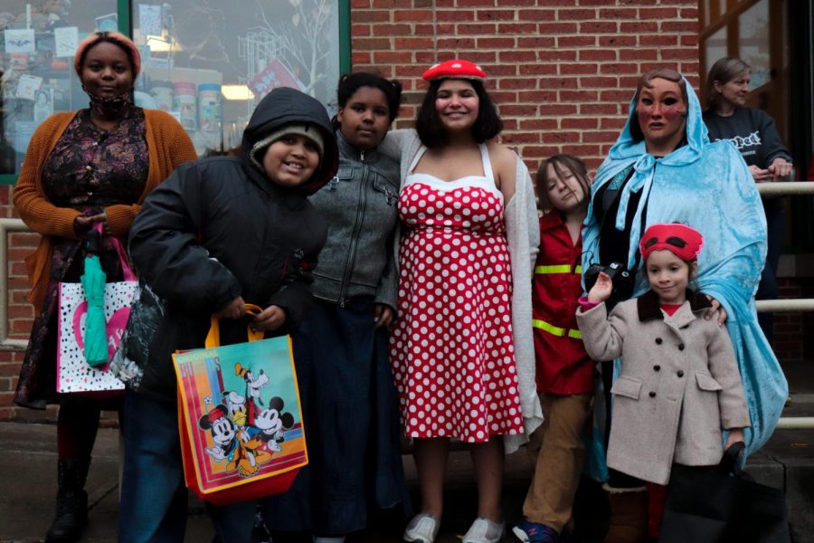 Angel Fischer, pictured in the blue cape and mask, takes her kids trick or treating in the downtown Kent halloween festivities on Friday, Oct. 29.