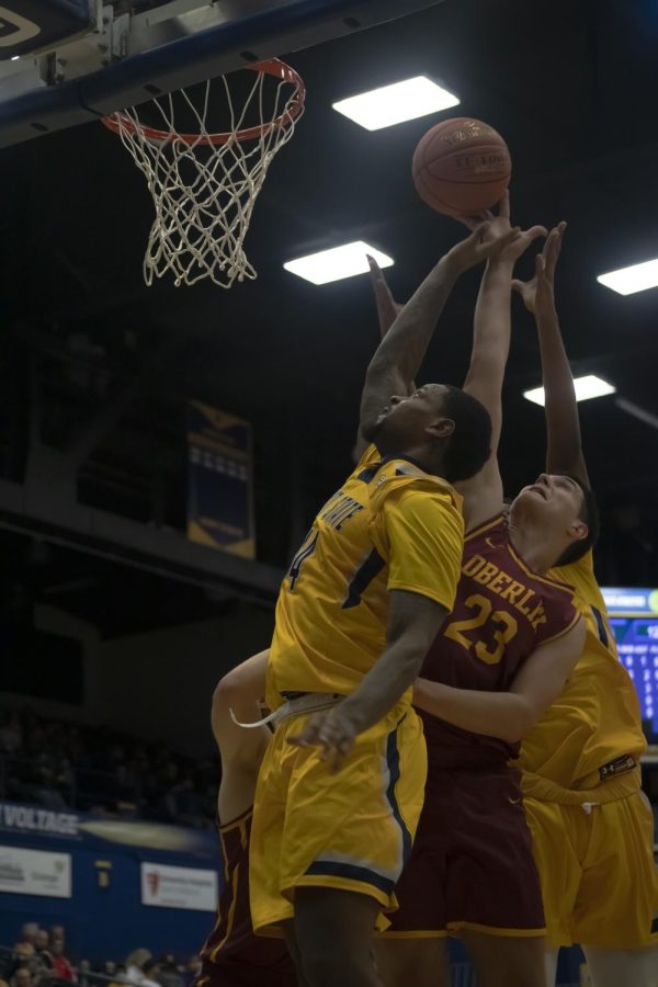 Redshirt senior forward Tervell Beck (14) fights to hit the ball into the net during the men's basketball game against Oberlin College on Nov. 16, 2021.