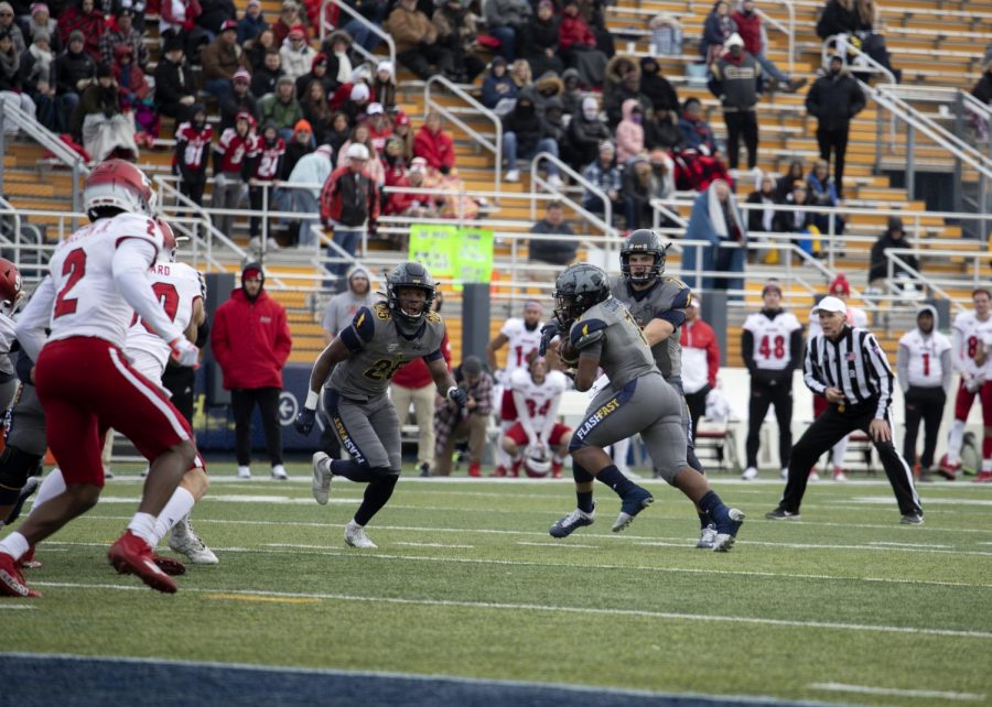 Quarterback Dustin Crum (7) hands the ball off to running back Marquez Cooper (1) during the football game against Miami University on Nov. 27, 2021. Kent State beat Miami University 48-47 in overtime.