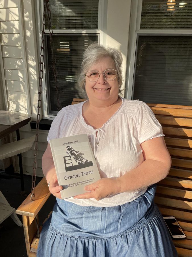 Judy Smith, owner of the houses located at 226 and 230 South Lincoln Street, holds the book "Crucial Turns" that references the street corner where she's spent most of her life.