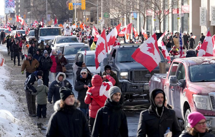 Trucks and supporters travel down Bloor Street during a demonstration in support of a trucker convoy in Ottawa protesting COVID-19 restrictions, in Toronto, Saturday, Feb. 5, 2022. (Nathan Denette/The Canadian Press via AP)