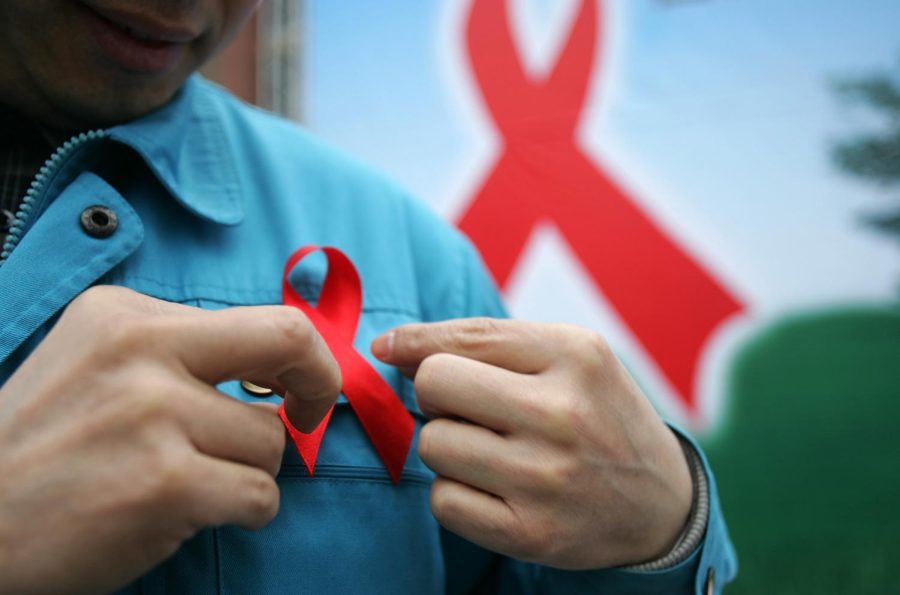 CHENGDU, CHINA - DECEMBER 1: (CHINA OUT) A migrant worker wears a red ribbon during an event organized by the local government to promote HIV/AIDS knowledge among migrant workers on December 1, 2005 in Chengdu of Sichuan Province, southwest China. China has pledged to keep the number of people living with HIV/AIDS below 1.5 million by 2010, Health Minister Gao Qiang stated at a media conference. (Photo by China Photos/Getty Images)