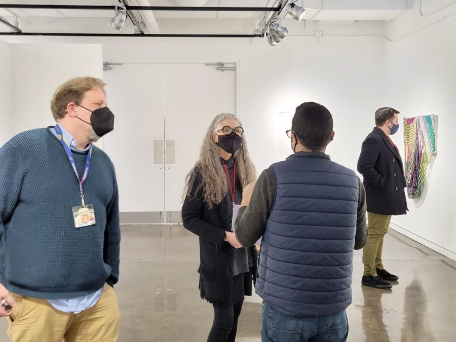 Janice Lessman-Moss, curator of Line by Line, talks to a group of gallery visitors.