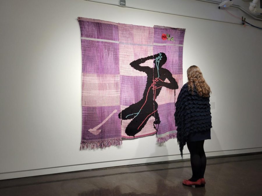 Helena Richardson, a graduate student at Kent State, stands in front of one of the tapestries featured at the Line by Line exhibit.