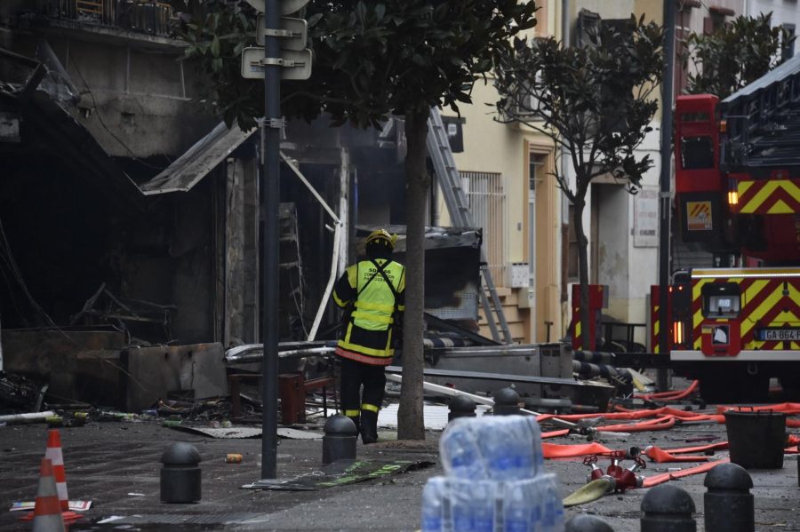 A firefighter stands near to debris and burned houses after an explosion in Saint-Laurent-de-la-Salanque, on February 14, 2022. - Five people died on the night of February 13, 2022, during a fire triggered by an explosion in a village in the Pyrenees-Orientales. (Photo by RAYMOND ROIG / AFP) (Photo by RAYMOND ROIG/AFP via Getty Images)