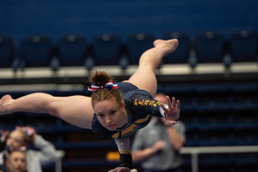 Rachel DeCavitch gracefully ascends the balance beam to start off her routine during the gymnastics meet against Rutgers and Cornell University on Jan. 28, 2022.