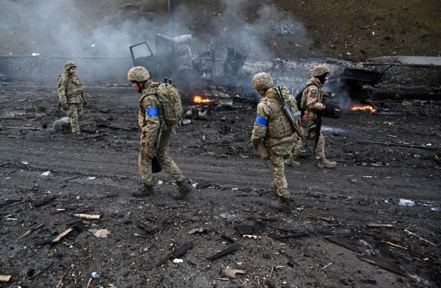 Ukrainian service members collect unexploded shells after a fighting with Russian raiding group in the Ukrainian capital of Kyiv in the morning of February 26, 2022, according to Ukrainian service personnel at the scene. (Photo by Sergei SUPINSKY / AFP) (Photo by SERGEI SUPINSKY/AFP via Getty Images)