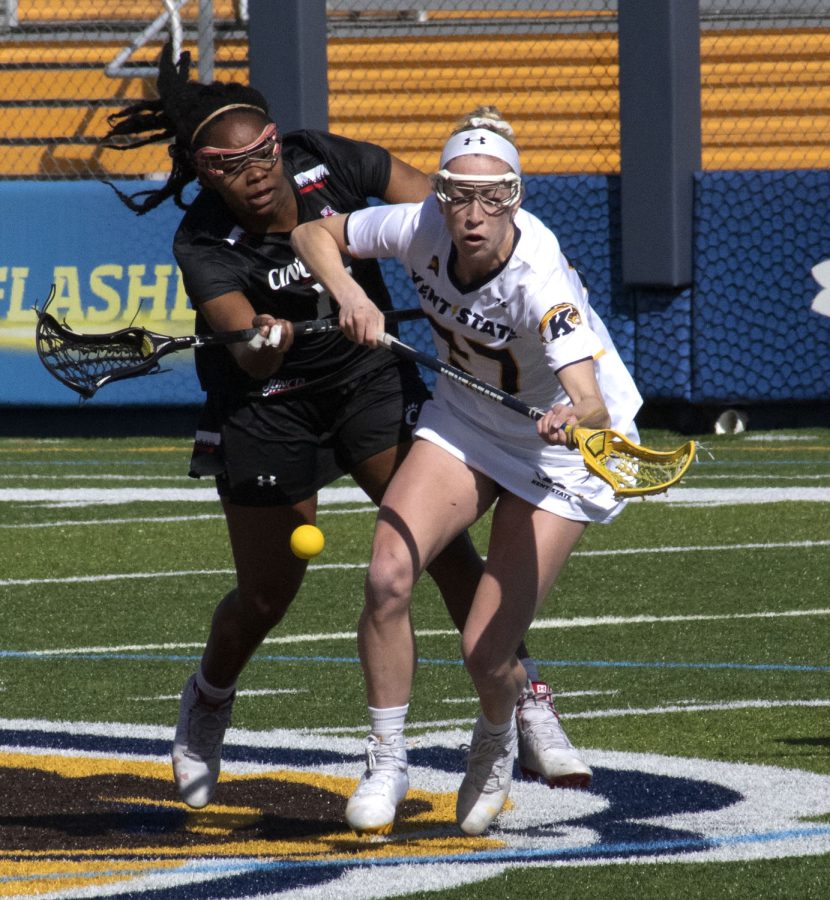 Sophomore midfielder Abby Jones [27] fights for the ball during the women’s lacrosse game on Mar. 8, 2020. Kent State University lost to University of Cincinnati 25-8. 