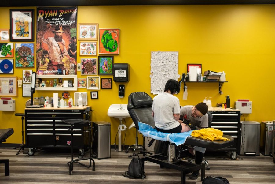 Apprentice Logan Thyr inks a tattoo on customer Cali Coreno. Black Sheep Tattoo Studios is located in downtown Ravenna.