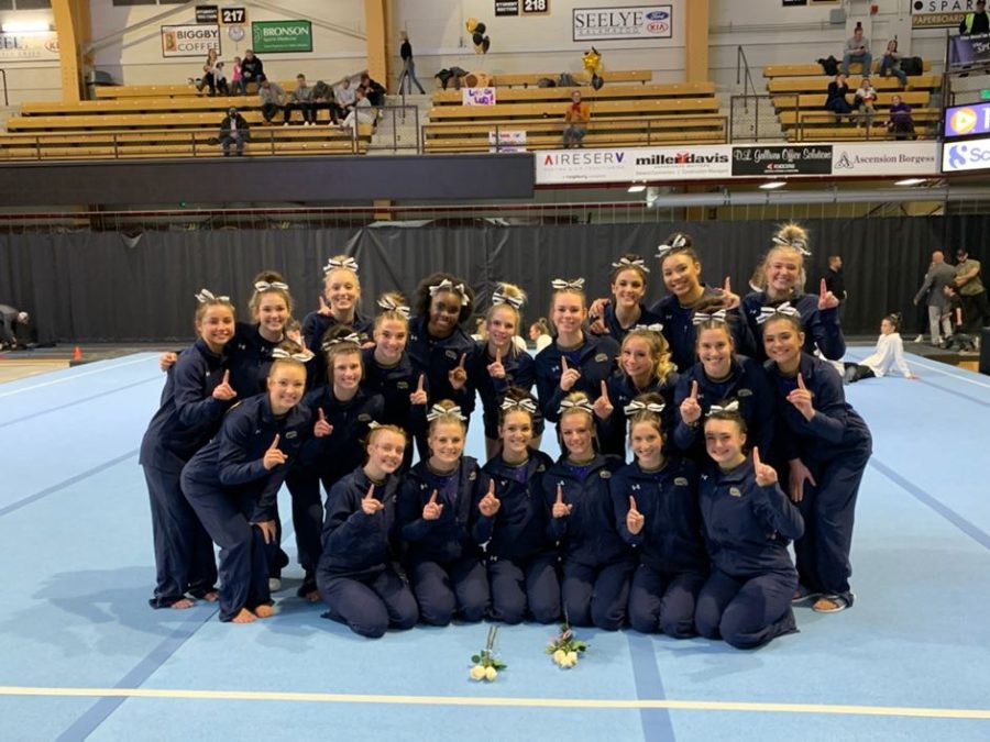 Members of the Kent State gymnastics team celebrate after beating Western Michigan to claim a share of the MAC regular season championship.