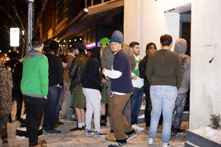 A line of students and community members stand outside 157 Lounge on Fake Paddy's Day. 