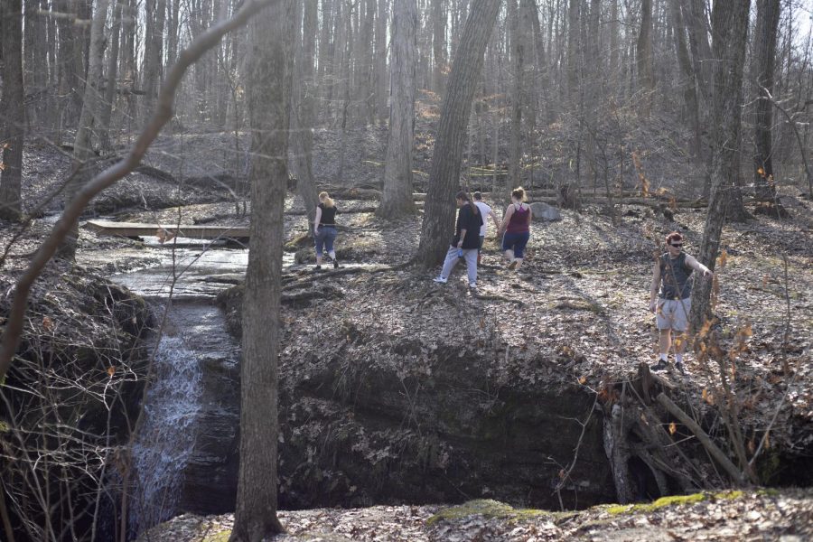 A family explores an area around a small waterfall in Nelson Ledge Quarry Park. 