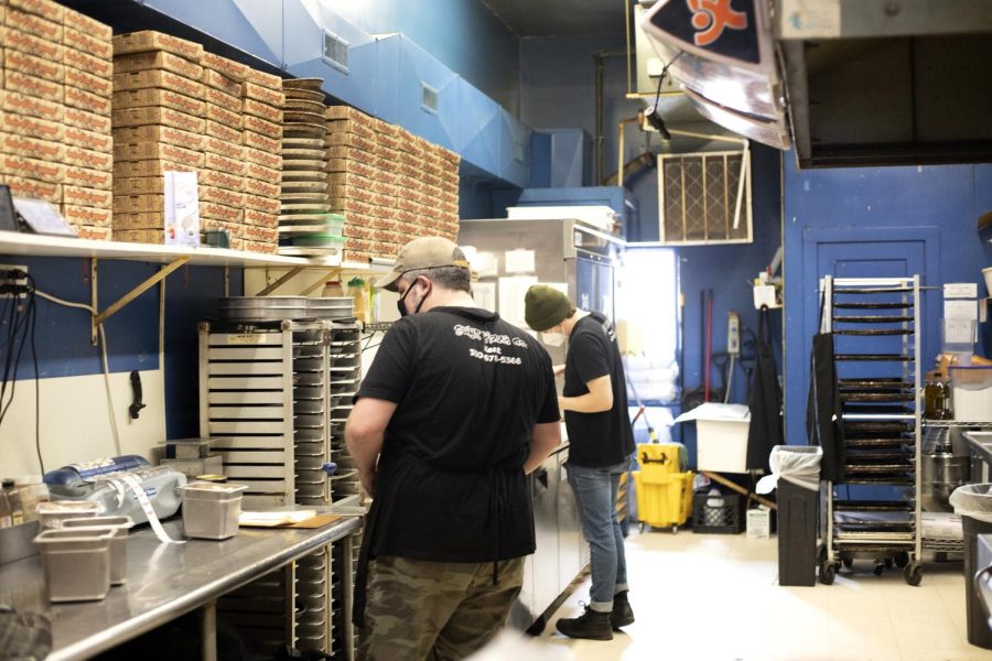 Manager Eric and a worker at Guys's Pizza Co. prepare pizza and other food.  Guy's Pizza Co. is located at 146 South Water Street in Kent, Ohio.