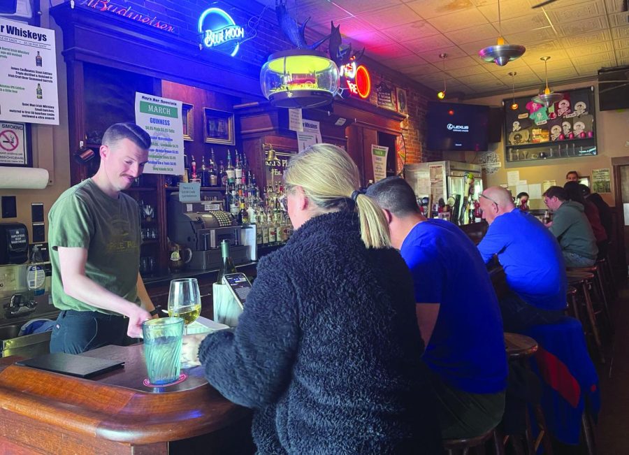 Bartender Chris Allen refills a drink for customers eating at the bar at Ray's Place on March 20, 2022. Ray's is located at 135 Franklin Ave.