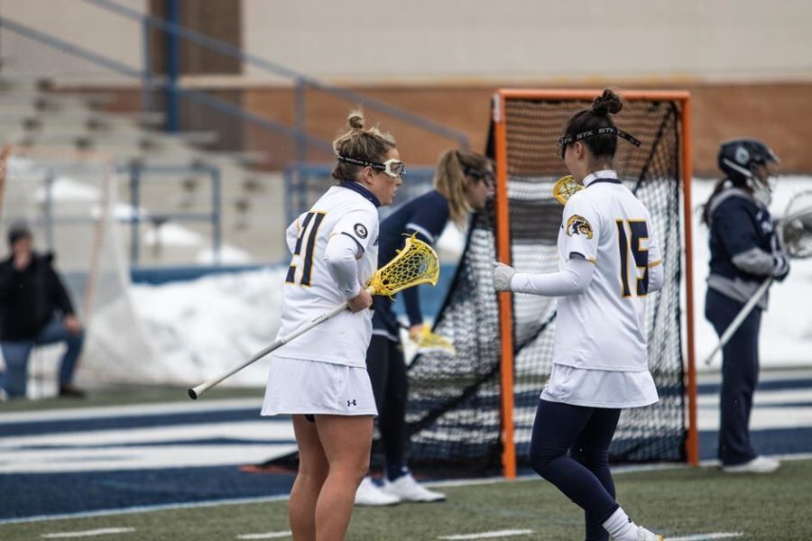 Senior attacker Kelli Bailey and junior midfielder Lexi Piekarski talk during the Kent State lacrosse team's loss against Robert Morris on Wednesday, March 2 in Kent, Ohio. 