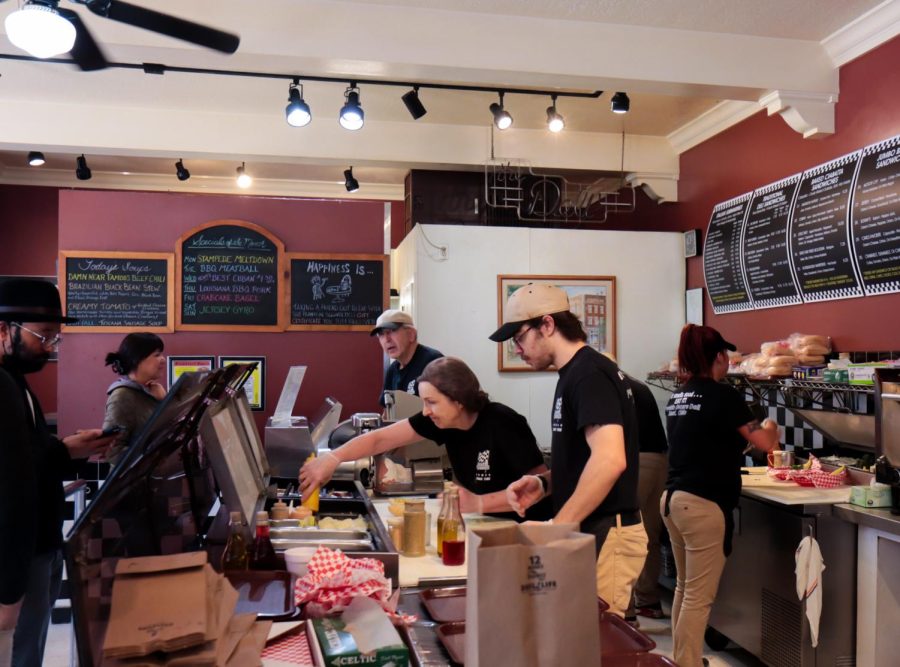 Carl Picelle, his wife and staff work hard making their sandwiches for customers during a lunch rush at their downtown Kent business, Franklin Square deli.