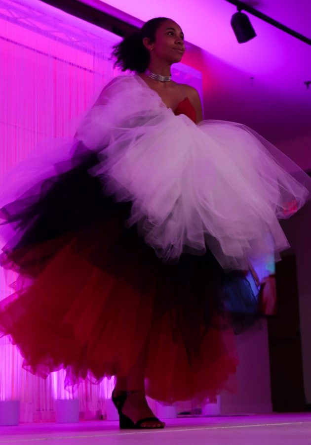 A model holds her layered dress as she walks down the runway at the KSU fashion show on Friday, April 29.