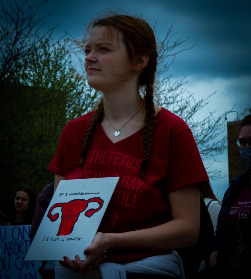 Lizzy stands with a sign at the protest for pro-choice rights listening to a speaker give a speech on Thursday, May 5. She said the governemnt should not have any say with what she does with her body.