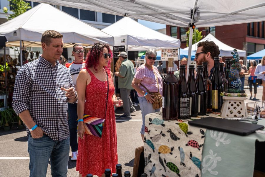 Drake Pregnal, Co-owner of Funky Turtle Brewing, serves patrons at the Art and Wine Festival on June 4, 2022. Drake is explaining the flavor notes of the wine he's serving.