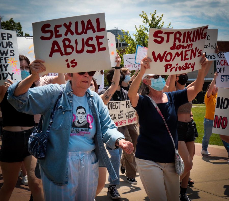 Two women hold signs intended to be read together. The signs stated "Sexual abuse is striking down women's privacy." The two were participants at a pro-abortion rights rally at Kent State on Wednesday, June 29.