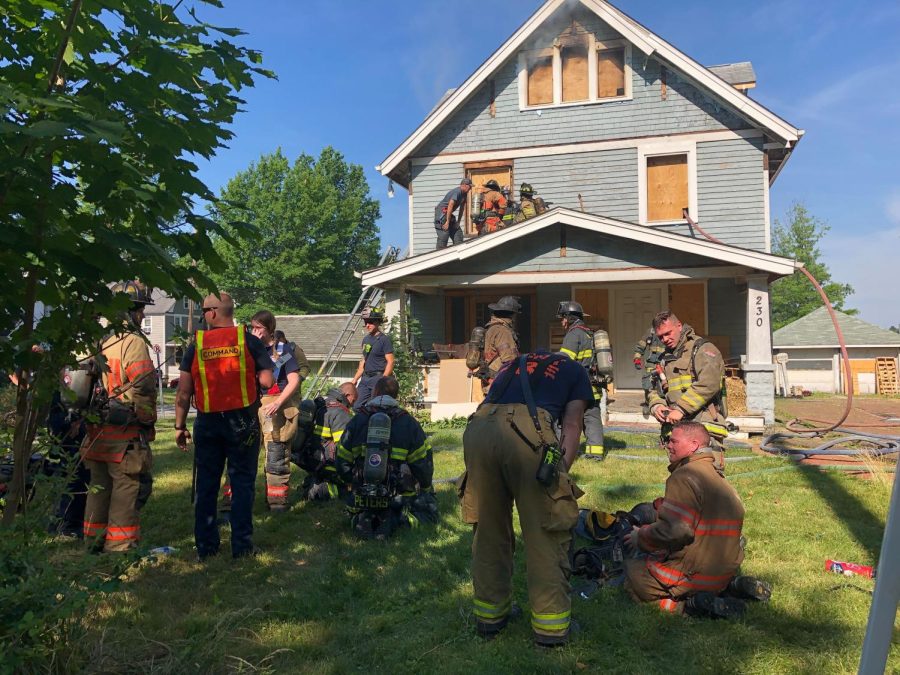 Trainees surround one of the vacant houses being filled with smoke as part of a training exercise.