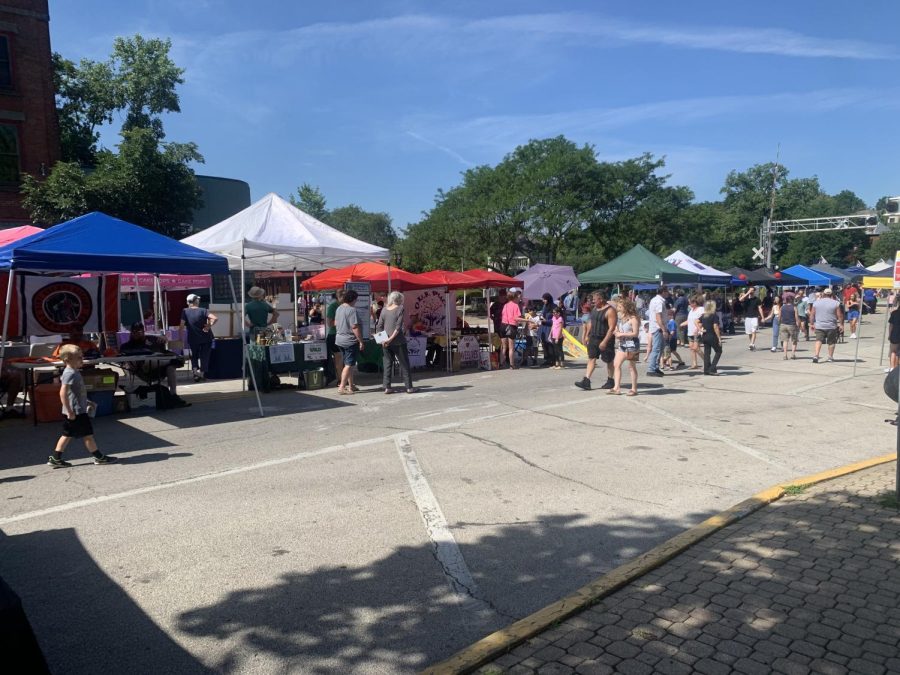 Attendees visit vendor booths and tables set up along Main Street.