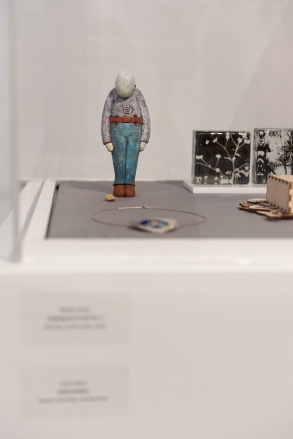 William Meyer's artwork, "Chasing the Crumb No. 2," is displayed in a glass case along with other Kent State artists' work.