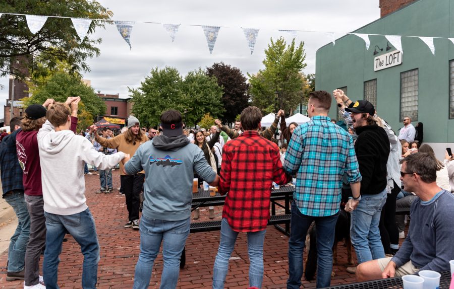 Attendees gather in a circle and sing "Sweet Caroline" by Neil Diamond with their friends.