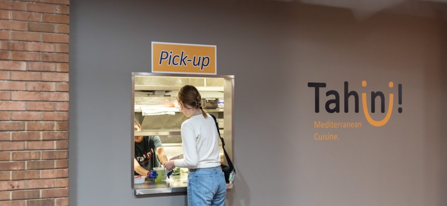 A student picks up her food from Tahini MC. The resturant caters to students who want Mediterranean food on campus.